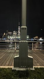 Illuminated bridge over river in city at night