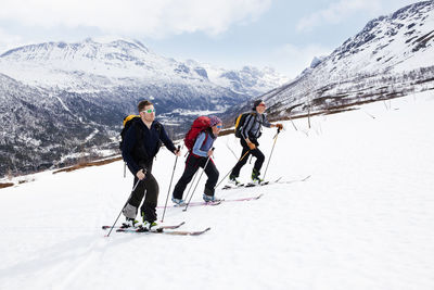 People skiing on snowcapped mountain during winter