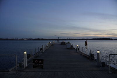 Pier over sea against sky during sunset