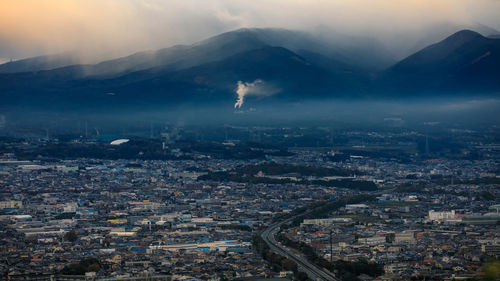 Dramatic and dark process cityscape in a strom and smog layer mountain background in japan