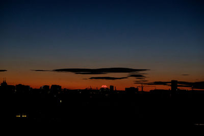 Silhouette cityscape against sky during sunset