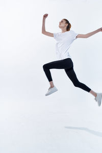 Woman with arms raised against white background