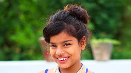 Close up of funny little girl with black eyes and blonde hair laughing,looking other side of camera 