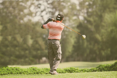 Rear view of man playing golf