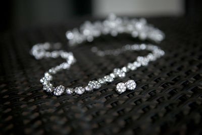 Close-up of diamond necklace and earring on table