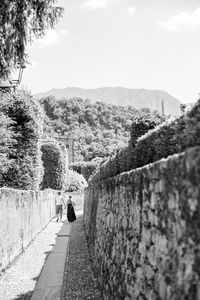 Rear view of woman walking on mountain against sky