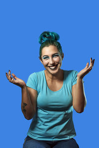 Portrait of smiling young man against blue background