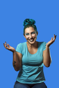 Portrait of smiling young man against blue background