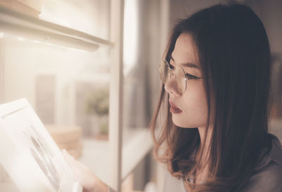 Portrait of young woman looking away at home