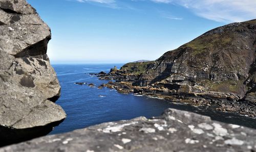 Rock formations by sea against sky