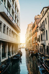 Canal amidst buildings in city against clear sky