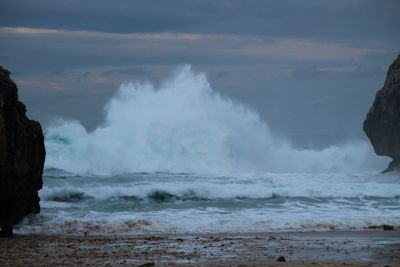 Waves splashing on sea against sky