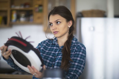 Young woman cleaning untensil at home