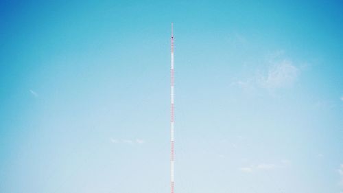 Low angle view of communication tower against blue sky during sunny day