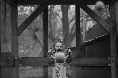 Full length of boy with toy standing against window