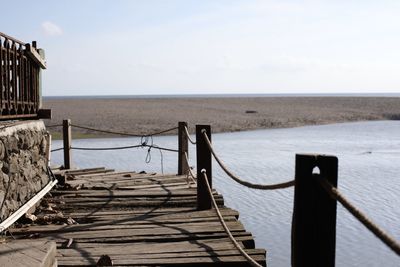 Wooden pier on sea against sky