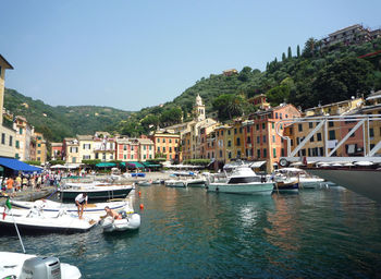 Boats in river with city in background