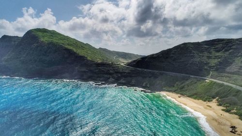 Scenic view of sea and mountains against sky