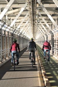 People riding bicycle on bridge