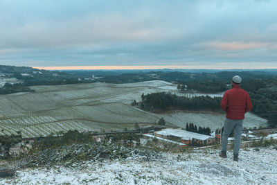 Rear view of man standing on snow covered land