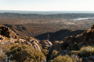 Rear view of man on rock against sky