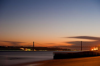 Suspension bridge over river at night