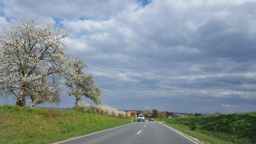 Empty road against cloudy sky