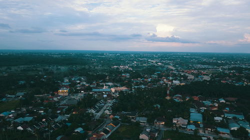 High angle view of townscape by sea against sky