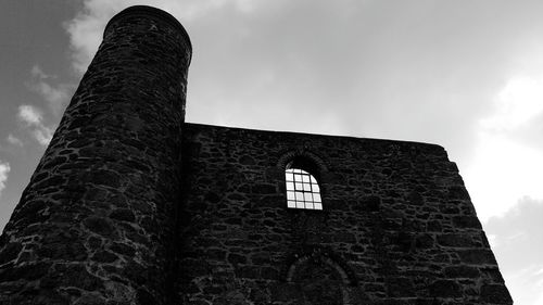 Low angle view of building against cloudy sky