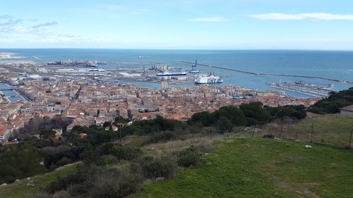 High angle view of town by sea against sky