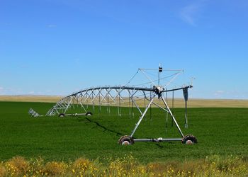 Agricultural machinery on farm against sky