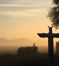 Silhouette statue against sky during sunset