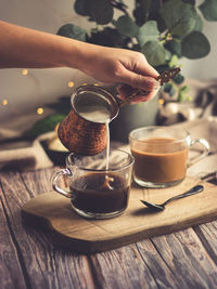 Hand holding coffee cup on table