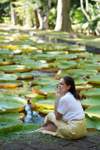 Side view of young woman sitting outdoors