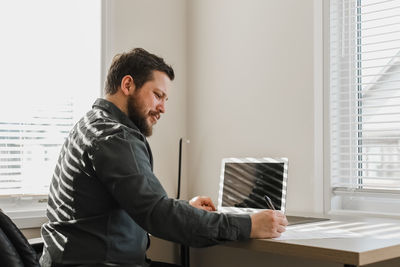 Side view of man working at home