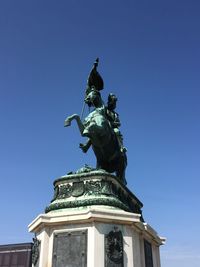 Low angle view of statue against blue sky
