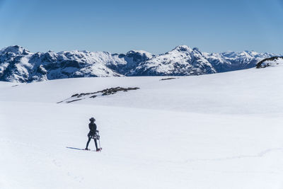 People skiing on snowcapped mountain against sky