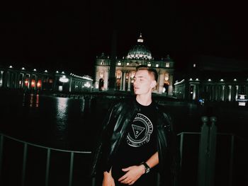 Portrait of young man standing at night