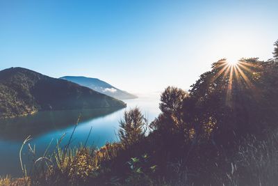 Scenic view of lake and mountains against clear sky