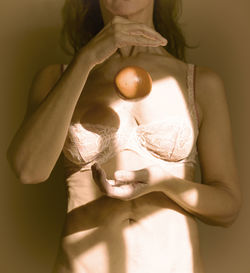 Midsection of woman holding heart shape