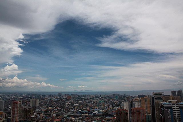 city, cityscape, building exterior, architecture, built structure, crowded, sky, skyscraper, cloud - sky, residential district, high angle view, residential building, residential structure, office building, city life, cloudy, modern, sea, cloud, aerial view