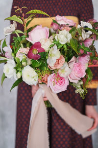 Close-up of hand holding rose bouquet