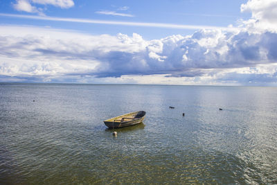 Boat moored on sea against sky