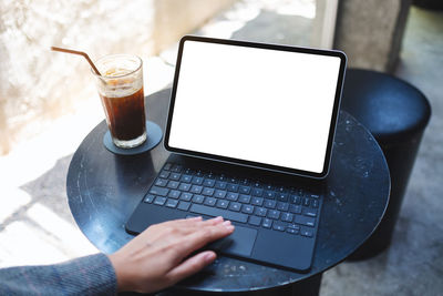 Midsection of woman using laptop on table