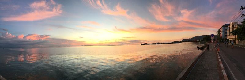 Panoramic view of sea against cloudy sky during sunset