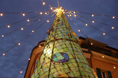 Low angle view of illuminated christmas tree against sky at night