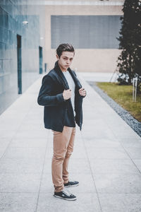 Full length of young woman standing on mobile phone