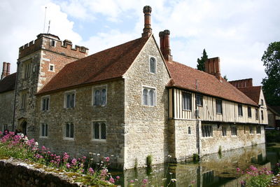 Exterior of old building by houses against sky