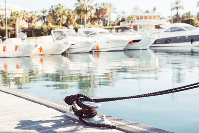 Close-up of rope tied to boat moored at lake