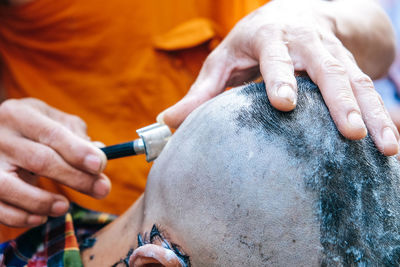 Close-up of man shaving head of boy